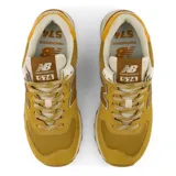 Championes New Balance 574 de mujer, en tonos mostaza y marrón, con entresuela ENCAP y el logotipo "N" en los laterales.