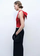 Top corto sin mangas de color rojo, con cuello redondo y diseño de espalda abierta con cierre de lazo. Cuenta con forro interior.