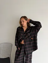 Pantalón de corte recto y holgado, confeccionado en tela de viyela con estampado de cuadros en tonos negro, gris y blanco. Presenta cintura elástica para mayor comodidad.