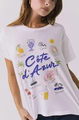 Remera blanca de manga corta con estampado gráfico alusivo a la Costa Azul y la Riviera francesa.