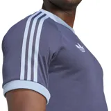 Camiseta Adidas color gris con detalles en celeste en cuello y mangas. Logo de Adidas a la izquierda y logo de la AFA a la derecha. Tres tiras celestes en ambas mangas.