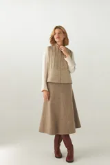 Chaleco corto entallado de lana fina sin teñir, color marrón claro jaspeado, con cierre frontal y alforzas verticales en delantera y espalda.