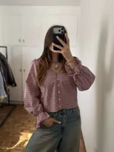 Blusa de manga larga abullonada con puños elastizados con volados, escote en V y cierre frontal con botones, con diseño a cuadros.