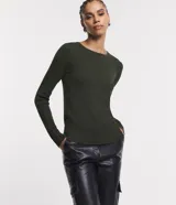 Suéter de punto color rosado, con cuello barco, mangas largas y puños con botones decorativos. El dobladillo también es acanalado.