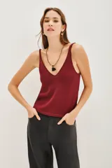 Musculosa de punto con acabado metalizado, escote en V y breteles anchos. Presenta un diseño liso y entallado.