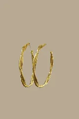 Aros tipo argolla dorados con diseño retorcido.