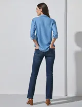 Camisa de manga larga de lyocell color azul claro, con cuello con solapa, escote en V y abertura central con botones. Presenta dos bolsillos aplicados en el frente.