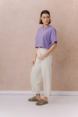Jeans de tiro alto y silueta barrel, color crudo, con cinco bolsillos, presillas para cinturón y cierre frontal con botón y cremallera. Presenta diseño de pierna amplia con leve entalle hacia el ruedo y dobladillo vuelto.