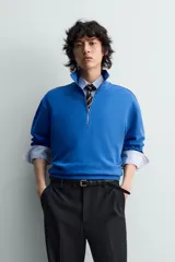 Sudadera de algodón azul con cuello alto y cierre frontal de cremallera de un cuarto. Presenta un corte regular y puños y bajo en rib.