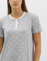 Camisón corto René Rofé de corte recto y textura acanalada, color blanco con estampado floreado en tonos celestes. Con mangas cortas, escote redondo y pechera frontal con abotonadura parcial.