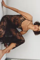 Vestido largo semitransparente confeccionado en encaje suave, con escote redondo, tirantes finos ajustables y bajo con acabado en ondas.