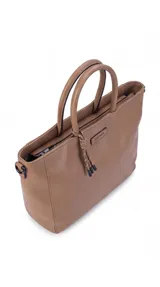 Cartera de formato amplio y estructurado, color marrón, con doble asa de mano y correa larga desmontable y regulable que permite llevarla al hombro o cruzada. Cuenta con cierre superior y aplique decorativo en el frente.