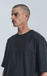 Remera negra de algodón premium, corte crop y oversize, con hombros caídos y cuello redondo.