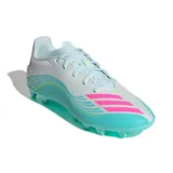 Championes de fútbol Adidas F50 Messi Club, diseñados para terreno firme y césped artificial. Presentan un diseño aerodinámico en color blanco con degradado en turquesa y detalles en fucsia y amarillo neón.