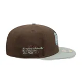 Gorra New Era modelo 5950 Diy Note, diseño estructurado con visera plana gris claro y corona marrón. Presenta un bordado frontal con las iniciales 'NC' y el texto 'New Era Cap'.