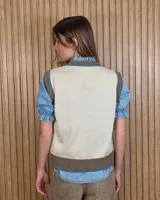 Chaleco tejido de punto 100% algodón, color crudo con detalles en tono tostado en el cuello redondo, sisas y dobladillo inferior.