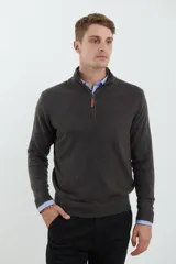 Sweater verde oliva de tejido acrílico con textura similar al cashmere, corte clásico, cuello alto con cierre metálico y tirador de cuerina ecológica.