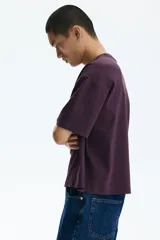 Remera boxy de algodón en punto liviano color bordó, de hombros caídos, cuello redondo ribeteado acanalado y corte oversized.