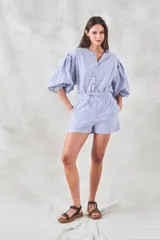 Camisa celeste a rayas verticales blancas, de corte holgado y mangas 3/4 abullonadas.