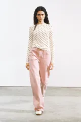 Camiseta de manga larga, cuello redondo, color blanco roto con estampado de lunares negros.