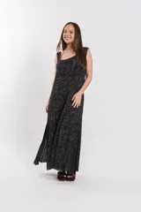 Vestido largo de punto con brillo, cuello cuadrado, sin mangas y tajos laterales profundos.