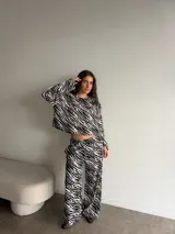 Remera manga larga de viscosa con estampado animal print tipo cebra en blanco y negro, corte holgado y cuello redondo. Presenta un pequeño parche cuadrado bordado en el pecho.
