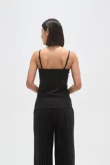 Musculosa de poliamida con breteles finos, corte al cuerpo y escote redondo.