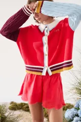Cardigan de punto con diseño tricolor, de corte relajado, manga larga de tejido trenzado en contraste de color, cuello solapa tipo polo y cierre frontal de botones.