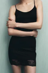 Vestido corto color marrón, confeccionado en mezcla de poliamida, con escote redondo y tirantes finos ajustables. El bajo está acabado con una aplicación de encaje combinado a tono.