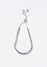 Pulsera de plata 925 tipo tennis con zirconias transparentes y verdes esmeralda intercaladas, cuenta con cierre corredizo ajustable.