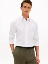Camisa de manga larga con diseño de rayas verticales finas y corte clásico, confeccionada en algodón. Cuenta con cuello abotonado, cierre frontal con botones, un bolsillo de parche en el pecho con el logo bordado de la marca y puños con botones.