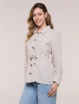 Sobrecamisa beige de lino liviano, con cuello camisero, cierre frontal de botones carey y bolsillos en el pecho. Cuenta con cordón ajustable en la cintura y mangas largas.