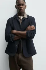 Sobrecamisa de corte regular fit confeccionada en tejido con mezcla de algodón con textura. Presenta cuello de solapa, manga larga con puños abotonados, dos bolsillos frontales de plastrón y cierre delantero con botones.