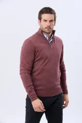 Buzo de tejido fino en hilo de algodón, color rosado, con cuello alto y cierre frontal parcial con detalle en cuero. Presenta puños y ruedo acanalados y un pequeño logo bordado en el pecho.