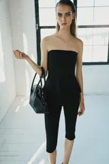 Pantalón capri negro de tiro medio y corte ajustado, confeccionado en tejido elástico con cintura elástica.