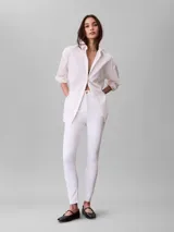 Jeans de corte skinny y talle alto, confeccionados en denim elástico de algodón. Presentan cierre con botón y cremallera, diseño clásico de cinco bolsillos y largo al tobillo.