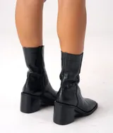 Bota de cuero vacuno color marrón con cierre lateral, taco de madera de 7cm y caña de 19cm.