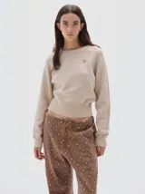 Jean estilo parachute de denim con estampado de rombos en tonos marrones. Presenta una silueta amplia, cintura ajustable con cordón y bajos con cordones para regular el ajuste.