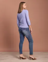 Cardigan blanco de tejido fino con abertura central y botones.