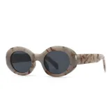 Lentes de sol con armazón ovalado de acetato en tono beige con efecto carey marrón. Cuentan con protección UV400.
