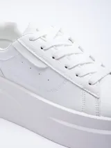 Zapatillas acordonadas color marrón con base de plataforma blanca y recortes texturizados.