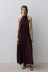 Vestido largo bordó con escote halter fruncido, cintura elástica y diseño sin mangas.