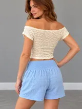 Falda tableada color azul, de corte corto con cintura elástica fruncida y cordón ajustable.