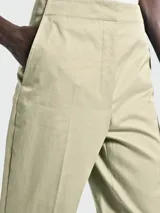 Pantalón de vestir color beige, de corte recto, con bolsillos laterales y traseros.