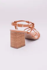 Sandalias negras de ecocuero con tiras finas que se cruzan en la capellada y se atan con nudos. Taco cuadrado simil madera.