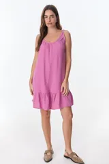 Vestido corto negro de tirantes finos con volados en el ruedo.