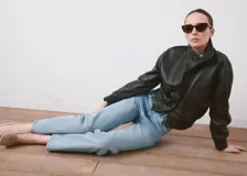 Jeans de denim celestes, de tiro alto y corte recto, con diseño clásico de cinco bolsillos y cierre frontal con botón y cremallera.