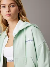 Buzo con capucha y cierre de cremallera color verde claro.