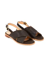 Sandalia plana de cuero craquelado color marrón, con tiras anchas cruzadas en el empeine, tira trasera ajustable con hebilla metálica dorada y pequeño tacón cuadrado.