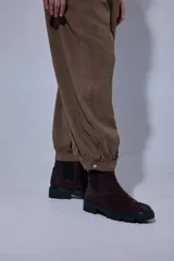 Pantalón tipo bombachita con pinzas que aportan volumen, confeccionado en Tencel. Presenta cierre frontal con botones dorados, bolsillos delanteros y ruedo ajustable mediante botón dorado.